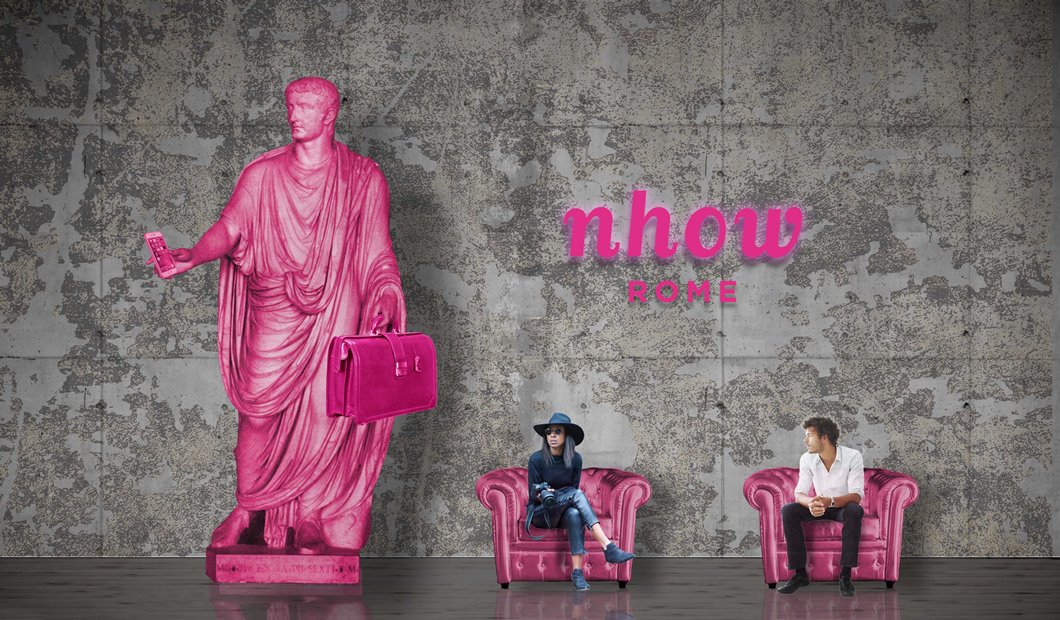 Un rendering del nhow Rome, con una statua di colore rosa e due persone sedute su poltroncine rosa