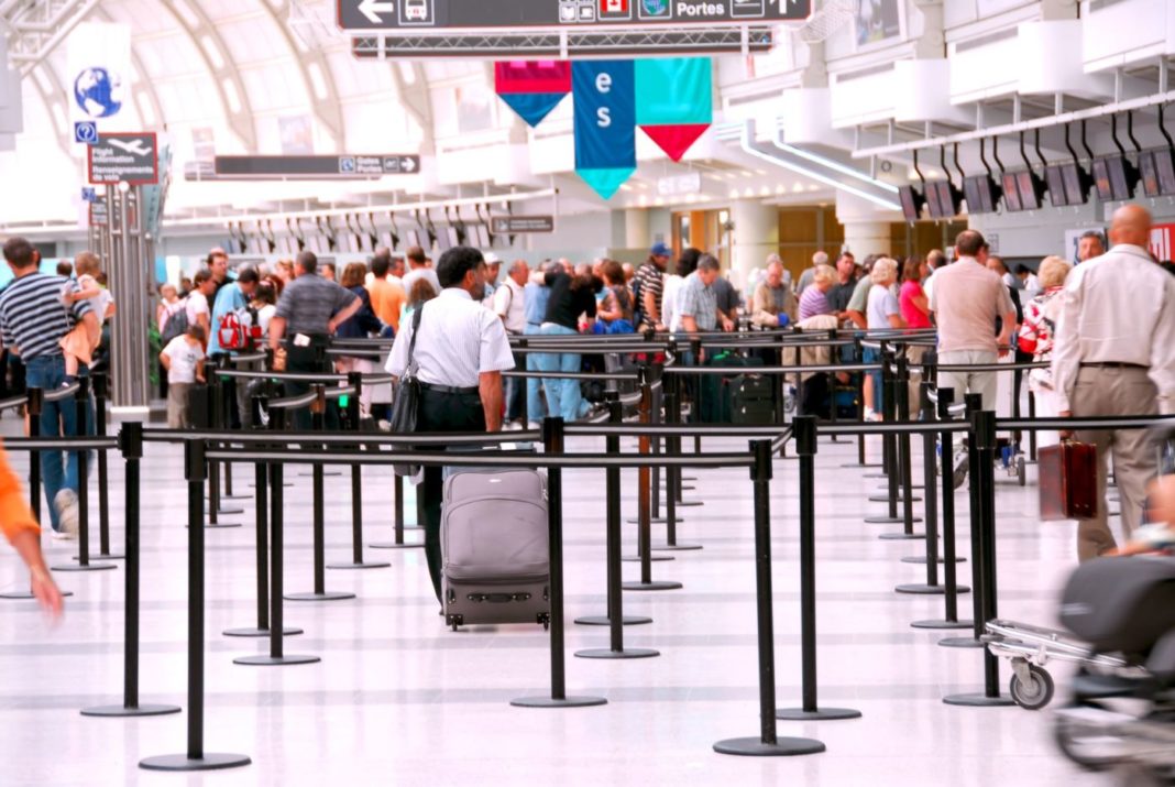Turisti in aeroporto in fila per il check in