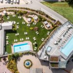 Una veduta aerea della zona piscina e solarium del Dolomiti Wellness Hotel Fanes
